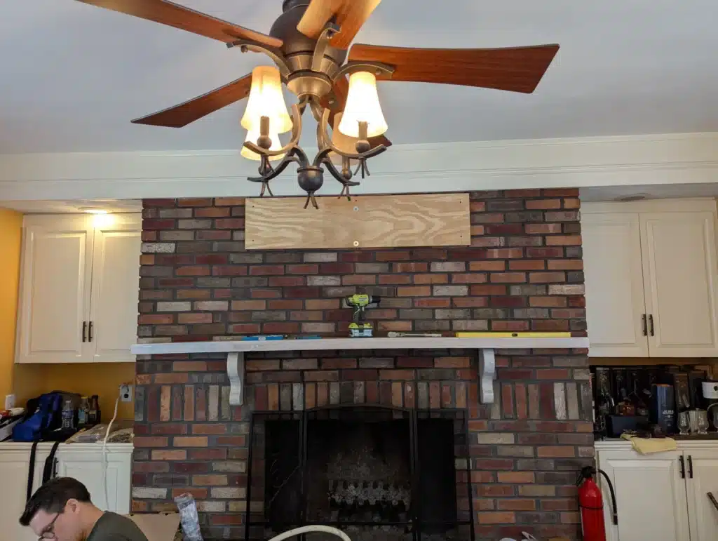 Plywood backer board installed on a brick fireplace before TV mounting by Horus Community Services in Trumansburg, NY