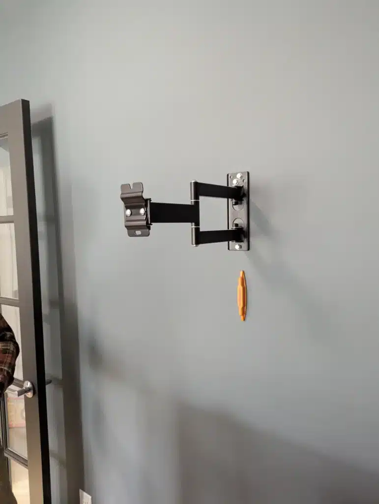 Full-motion articulating TV wall mount installed on a wall before the TV by Horus Community Services in Trumansburg, NY