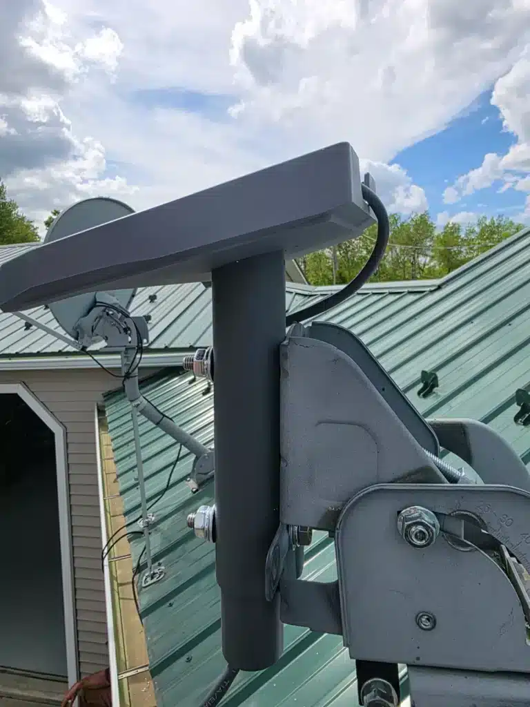Close-up of Starlink dish mount hardware installed on a metal roof by Horus Community Services in Trumansburg, NY