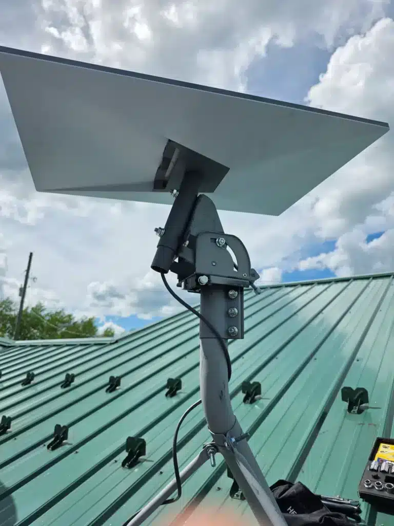 Close-up of a completed Starlink satellite dish mounted on a metal roof by Horus Community Services in Trumansburg, NY