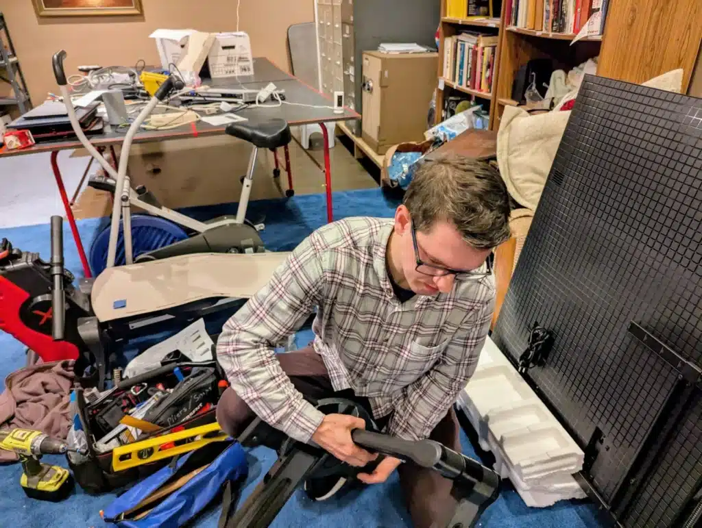Horus Community Services technician assembling TV mount hardware on site in Trumansburg, NY
