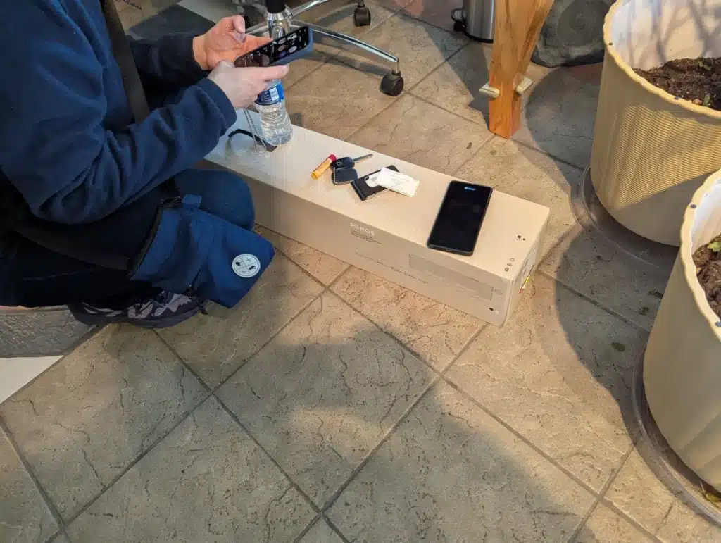 Horus Community Services technician preparing TV mount hardware on a wooden board before installation in Trumansburg, NY