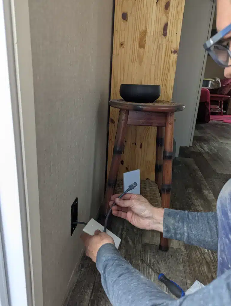 Horus Community Services technician installing a low wall data plate in Trumansburg, NY