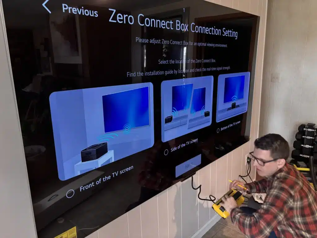 Horus Community Services technician configuring a Samsung Zero Connect wireless box for a wall-mounted TV in Trumansburg, NY